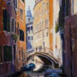 Venice side canal with people crossing bridge